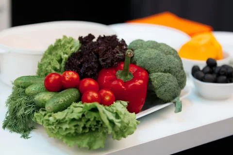 Composition of vegetables. On the plate is broccoli, cherry tomatoes, peppers Stock Photos