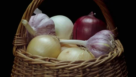 Composition of vegetables, rotation of a basket with onions and garlic on a b Stock Footage 148535801
