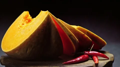 Composition of vegetables, rotation of pumpkin slices on a black background Stock Footage 150199899