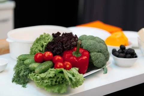 Composition of vegetables on table. On the plate is broccoli, cherry tomatoes Stock Photos