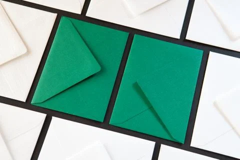 Composition with white and green envelopes on the table. 库存照片