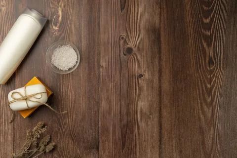 Composition with white bottle, soap and salt on wooden background. Stock Photos