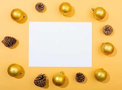 Composition of white card with copy space framed with baubles and pine cones on Stock Photos