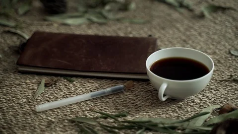 Composition with wicker mat, dry plants, a notebook and a cup of coffee. Close Stock Footage 124861574