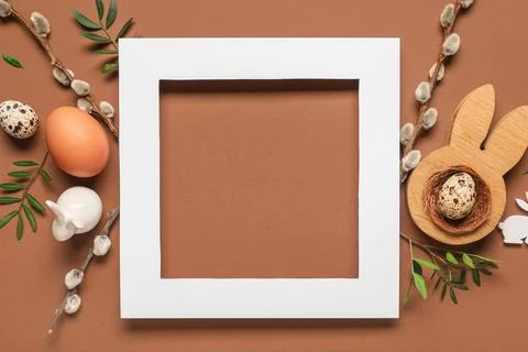 Composition with wooden frame, Easter eggs, pussy willow branches and green l Stock Photos