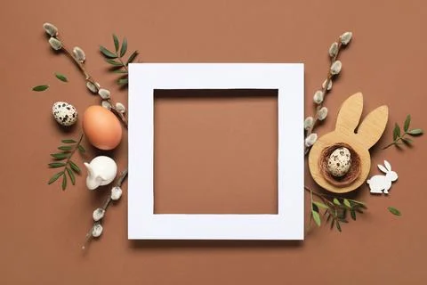 Composition with wooden frame, Easter eggs, pussy willow branches and green l Stock Photos