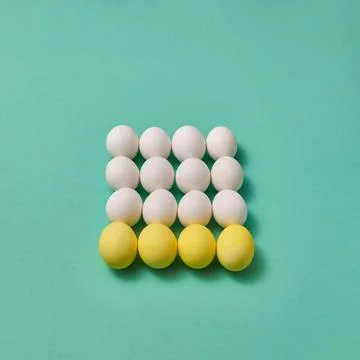 A composition of yellow and white eggs in the shape of a square presented ... Foto stock