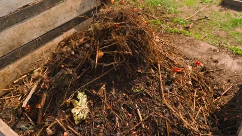 Compost being thrown onto compost heap with debris flying in air Stock Footage 337866686
