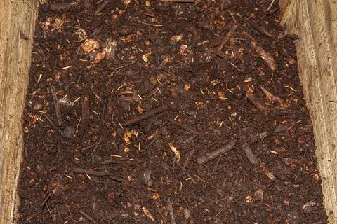 Compost in composter with organic materials, kitchens scraps, yard waste in c Stock Photos