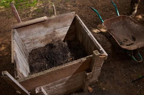 Compost heap. Compost pit on the plot of land. Wooden box for fertilizer and Fotos de archivo