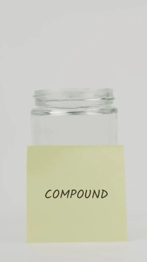 Compound text or word on yellow sticky note attached to glass jar with hand Stock Footage 311695665