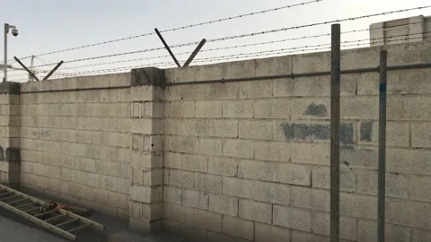 Compound wall using Solid block wall materials with Fencing and security camera Stock Footage 168864812
