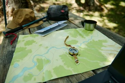 Comprehensive Camping Setup on Wooden Table with Map and Compass Stock Photos