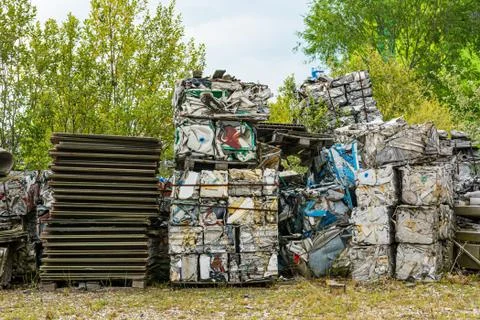 Compressed aluminium scrap in large cubes forming landfill in piles. Stock Photos