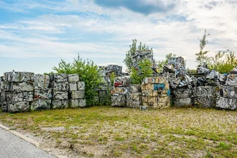 Compressed aluminium scrap in large cubes forming landfill in piles. Stock Photos