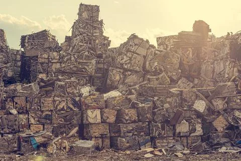 Compressed aluminium scrap in large cubes forming landfill in piles. Stock Photos