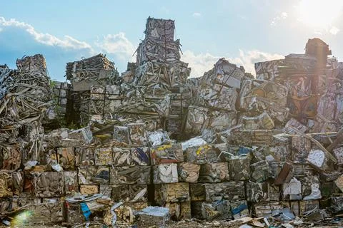 Compressed aluminium scrap in large cubes forming landfill in piles. Stock Photos