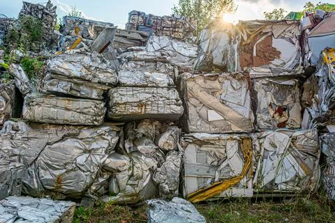 Compressed aluminium scrap in large cubes forming landfill in piles. Stock Photos