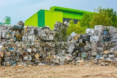 Compressed aluminium scrap in large cubes forming landfill in piles. Stock Photos