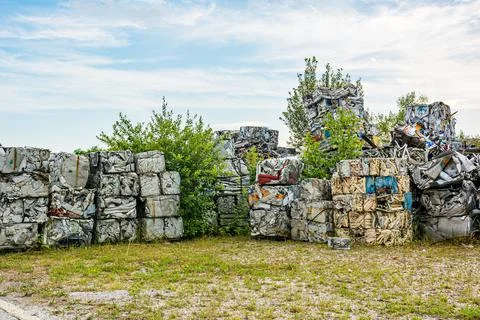 Compressed aluminium scrap in large cubes forming landfill in piles. Stock Photos