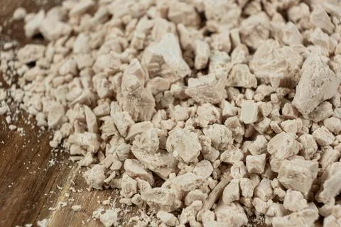 Compressed fresh yeast cubes close-up on a wooden background. Stockfoto's