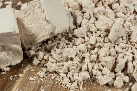 Compressed fresh yeast cubes close-up on a wooden background. Stockfoto's