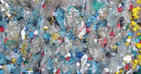 Compressed plastic bottles with colored caps. Close-up. Waste recycling stage. Stock Footage 156045699