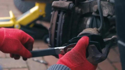 Compressing brake caliper piston with specialized repair tool during car brake Stock Footage 340195407