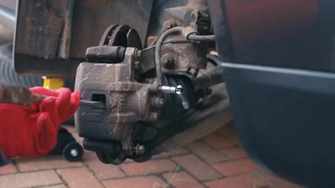 Compressing brake pads and caliper piston during brake service with brake fluid Stock Footage 340195396