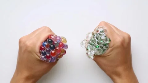 Compression of colored, multicolored hydrogel small balls Anti-stress ASMR video Stock Footage 254704020
