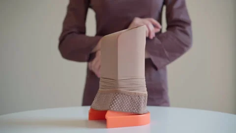 Compression stocking stretched on assist device rotating on turntable Stock Footage 321709453