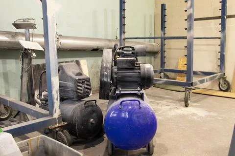 The compressor is on the floor in the painter's workshop, the working equipme Stock Photos