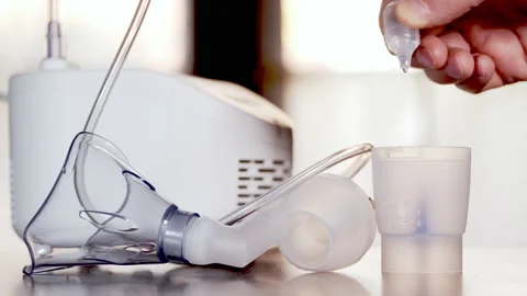 Compressor nebulizer with a face mask container being filled with medicine 動画素材 166954966