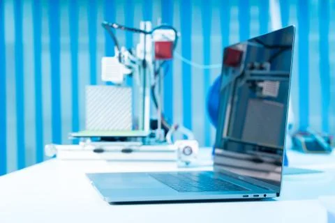 Computer and 3d printer on table in industrial design lab Stock Photos