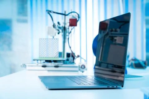 Computer and 3d printer on table in industrial design lab Stock Photos