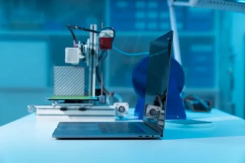 Computer and 3d printer on table in industrial design lab Stock Photos