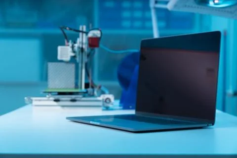 Computer and 3d printer on table in industrial design lab Stock Photos