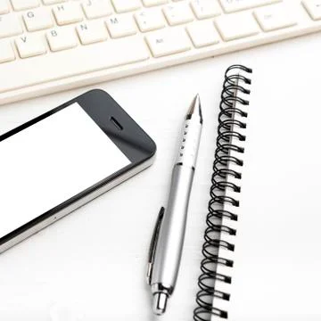 Computer and cellphone with notebook and pen Stock Photos