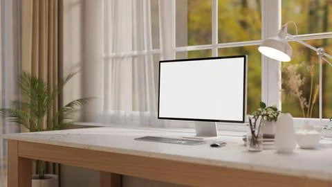A computer and decorative items on a white marble desk, set against a windo.. 库存插图
