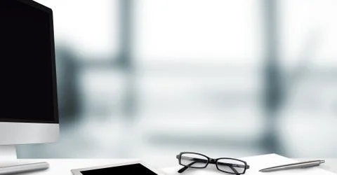 Computer and desk against blurry grey window Stock Illustration