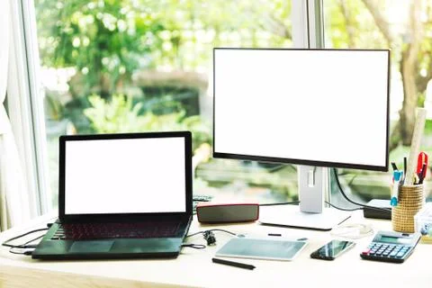 Computer and laptop with blank screen on table.Comfortable working place with Stock Photos
