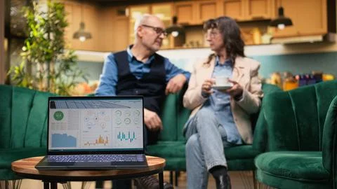 Computer app managing clean renewable energy at home for elderly couple 库存照片