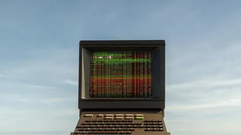 Computer on a beach with data and code on screen Stock Photos