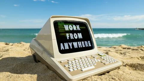 Computer on a beach with words work from anywhere on screen Stock Photos