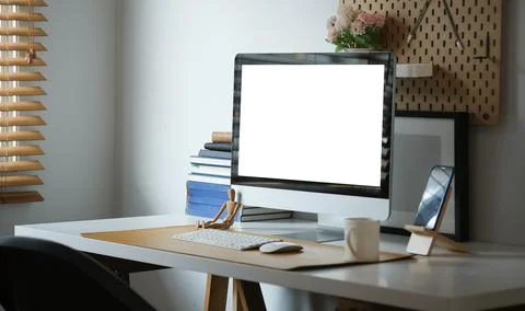 Computer with blank white display and supplies on white table. Foto stock