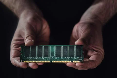 Computer board with a ram memory chip in the hands of a man on a black backgr 스톡 사진