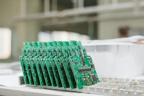 Computer boards stand in a row at the factory for the production of spare parts. Stock Photos