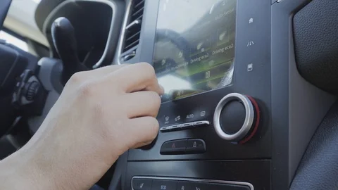 The computer is in the car. The man presses the control screen to change the Vídeo Stock 89000357