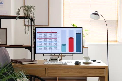 Computer with chart on desk in data scientists office 库存照片
