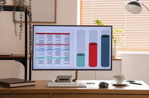 Computer with chart on desk in data scientist's office Foto stock